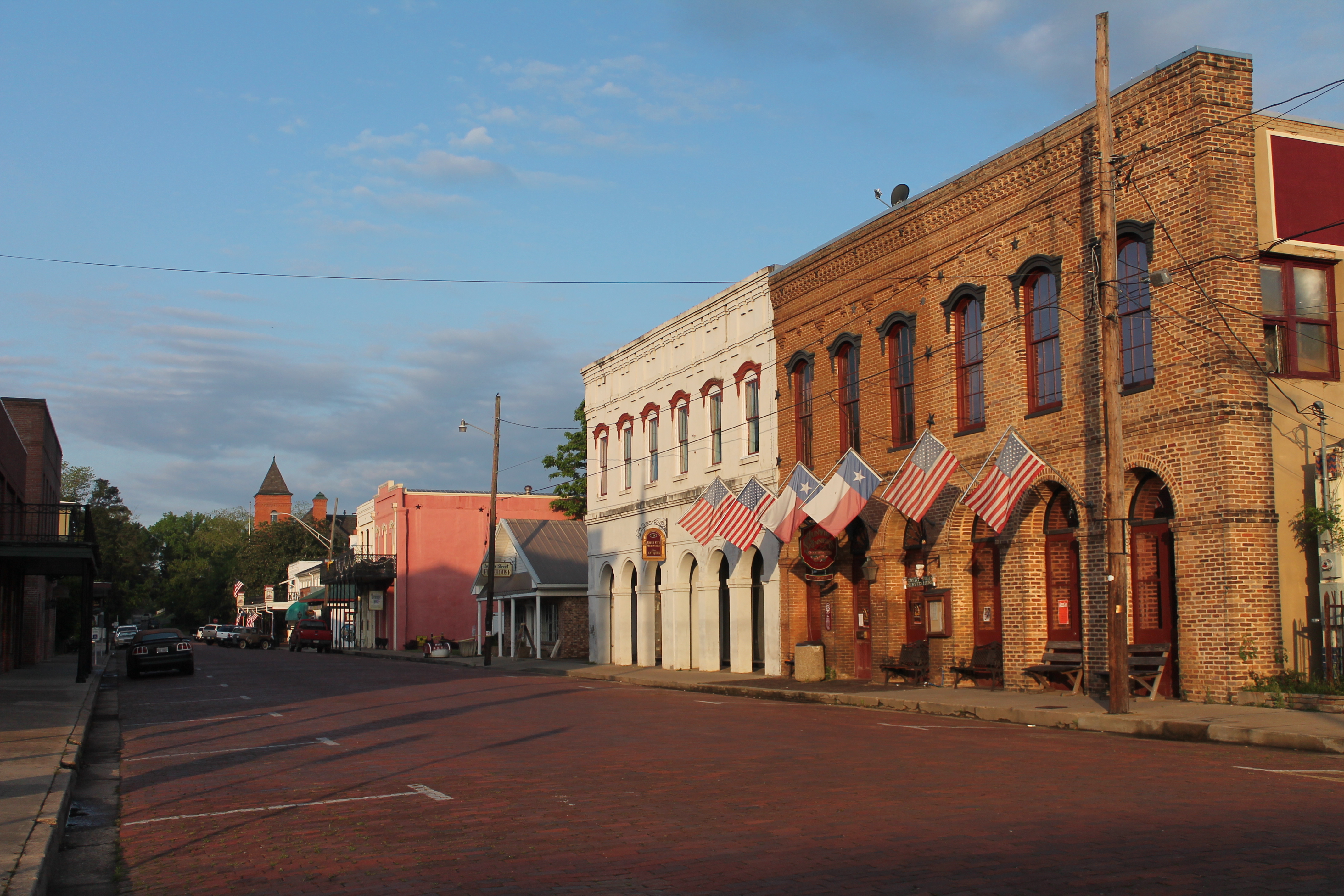 Historic brick storefronts and Texas flags in downtown Jefferson, Texas